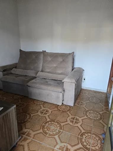 Sala de convivência com sofá amplo, onde os moradores assistem televisão e recebem visitas